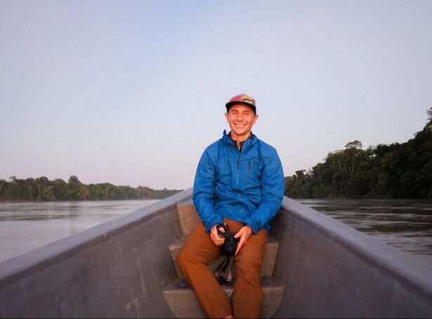 Me, smiling with my camera on a canoe in the Amazon